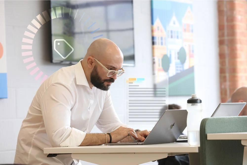 Legal professional working on a laptop in a collaborative office environment, representing focused legal analysis supported by intelligent document technology.