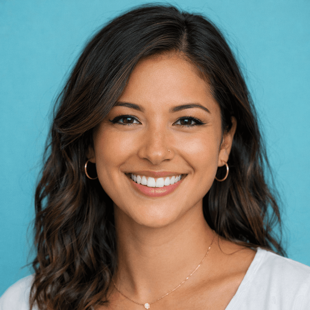 Smiling woman with long blonde hair, outdoors against a leafy background. She wears a black top, exuding a cheerful and relaxed vibe.