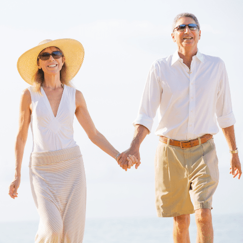 Portrait of a woman with curly hair, wearing a burgundy blouse, standing in soft natural light with a neutral background.