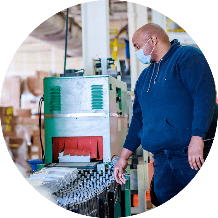 A person wearing a mask inspecting a production line