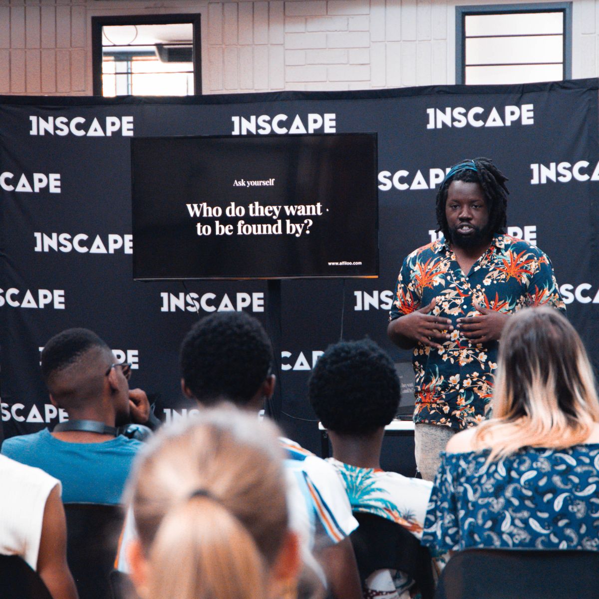 a man sitting at a desk talking on a cell phone