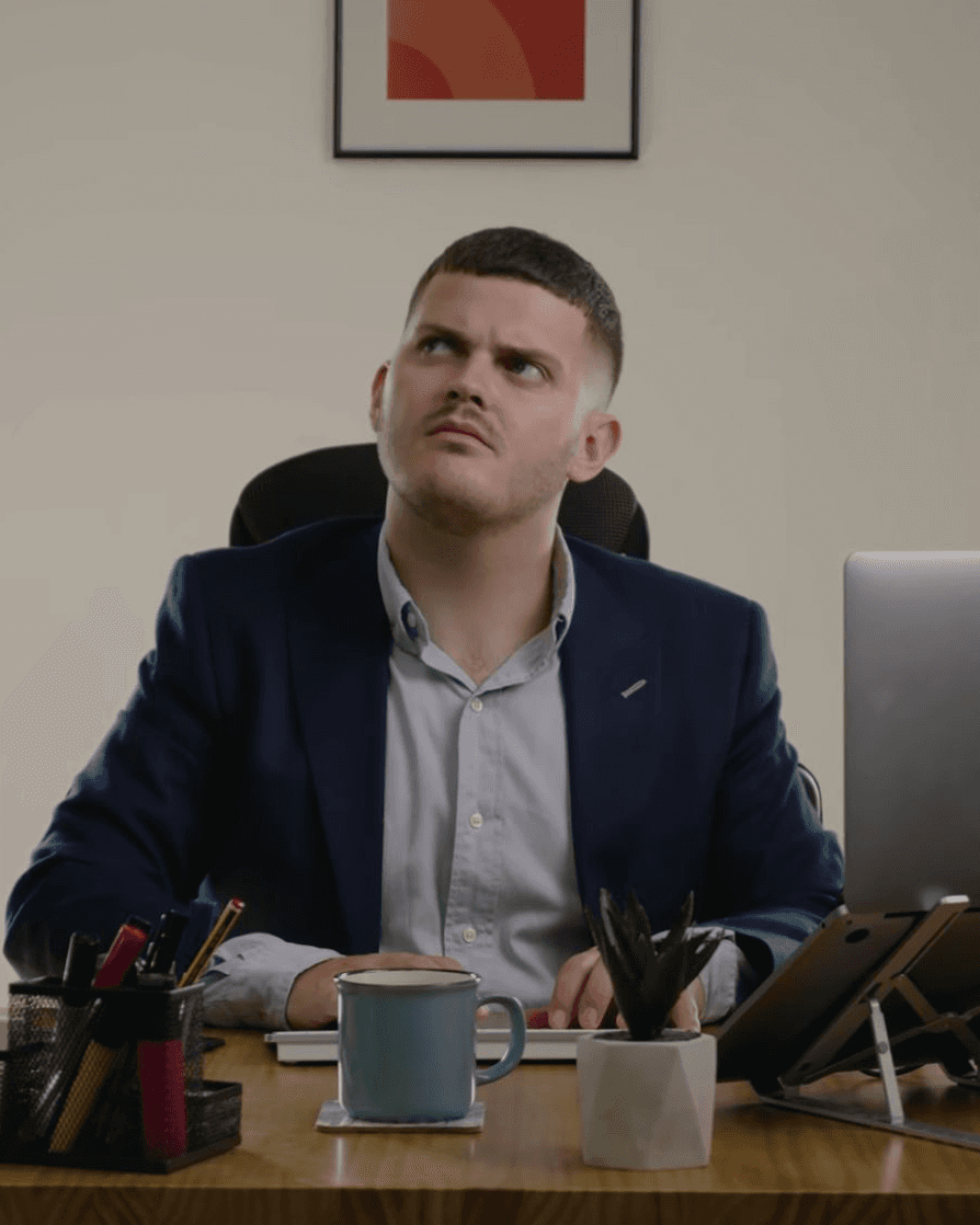 Jim, a fictional sales manager, looking puzzled at his desk in the CloudTalk commercial