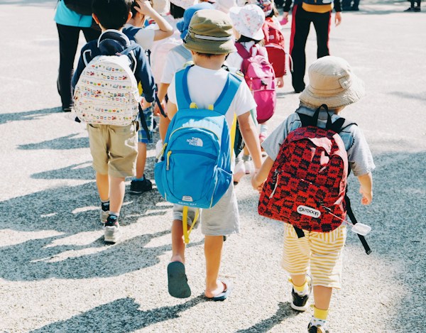 Niños con mochilas entrando al colegio: responsabilidad civil de un colegio