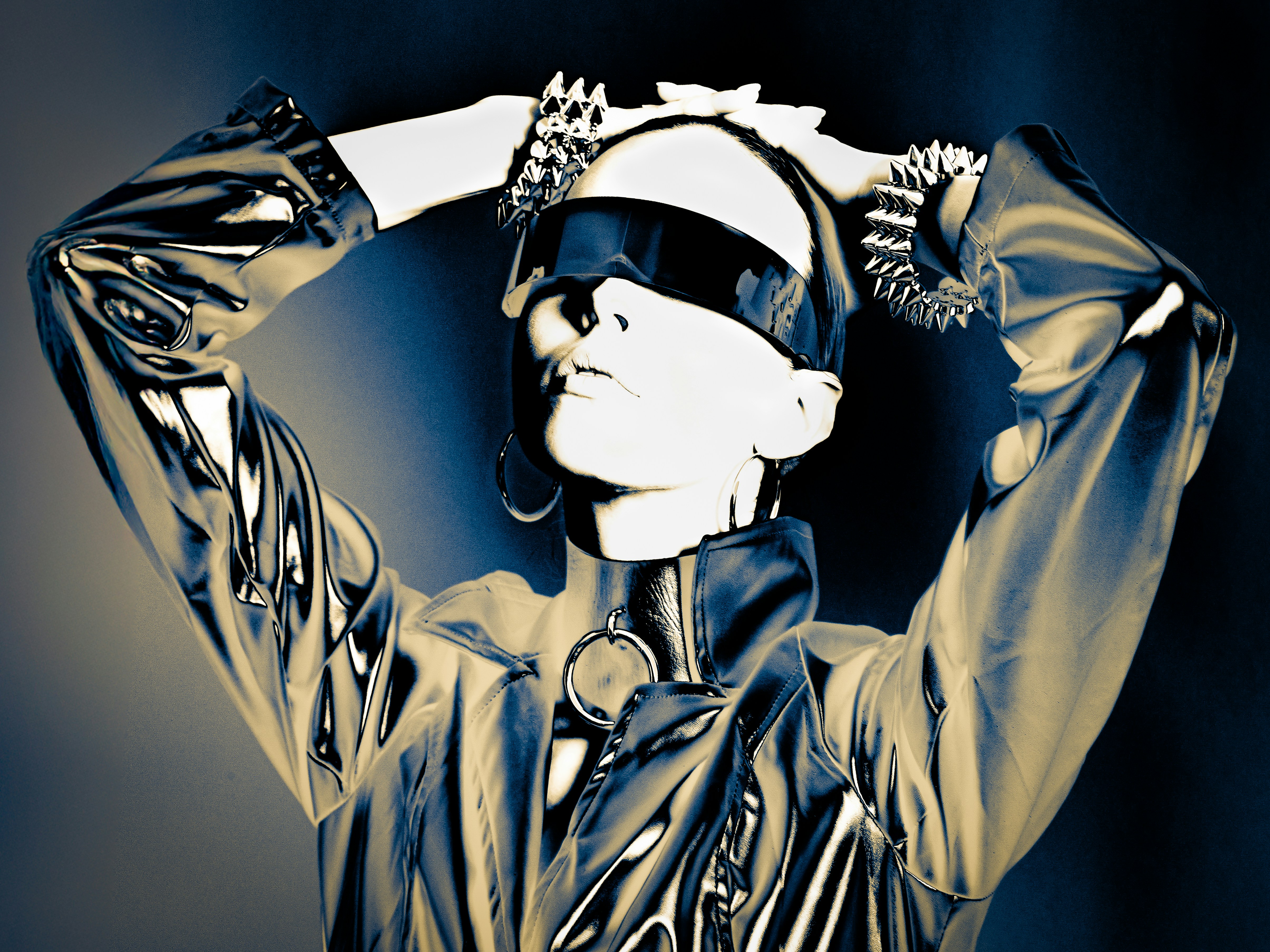 Woman in shiny outfit with blindfold and jewelry