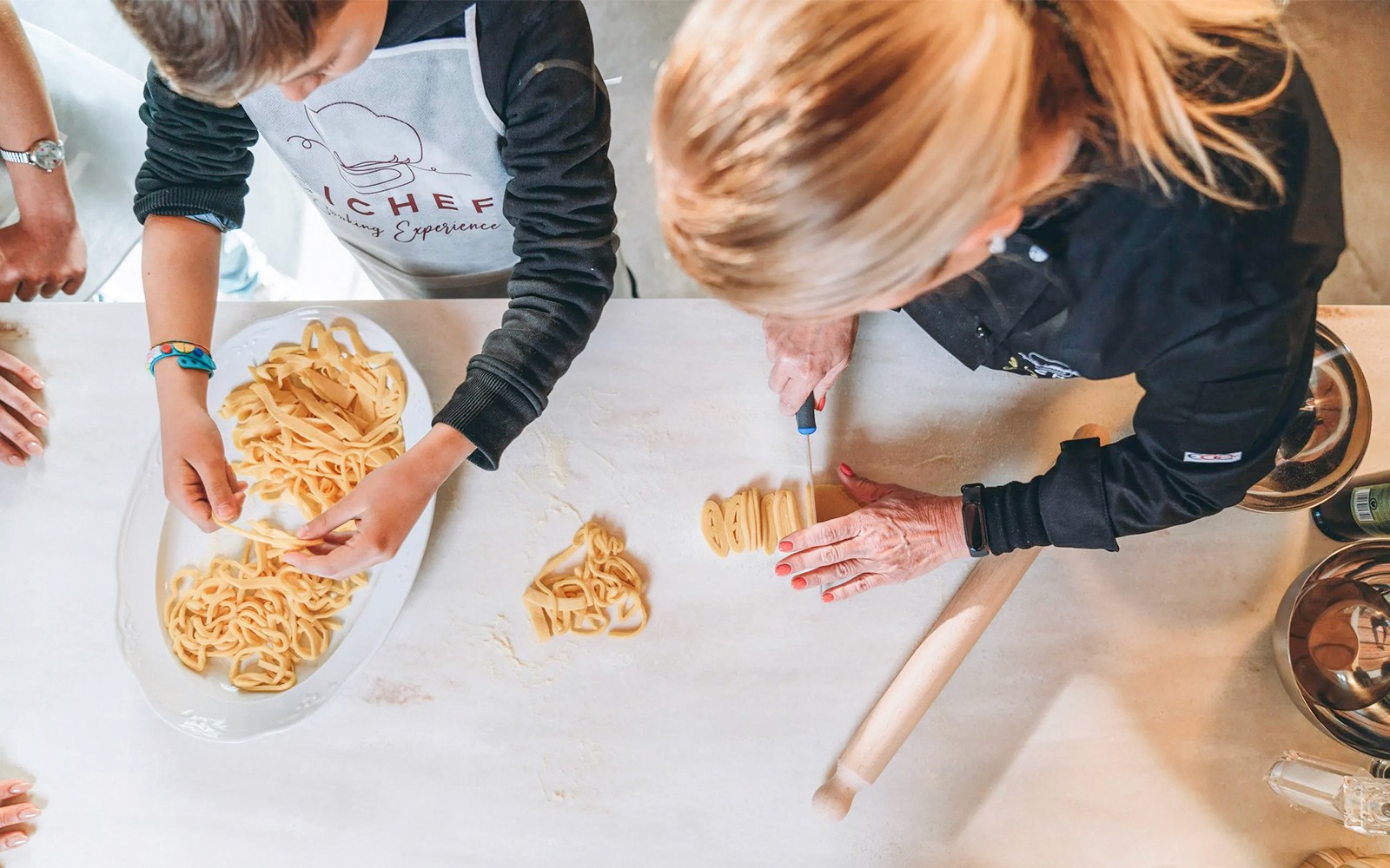 Frische Pasta in einem Kochkurs mit einem Koch und Teilnehmer zubereiten.