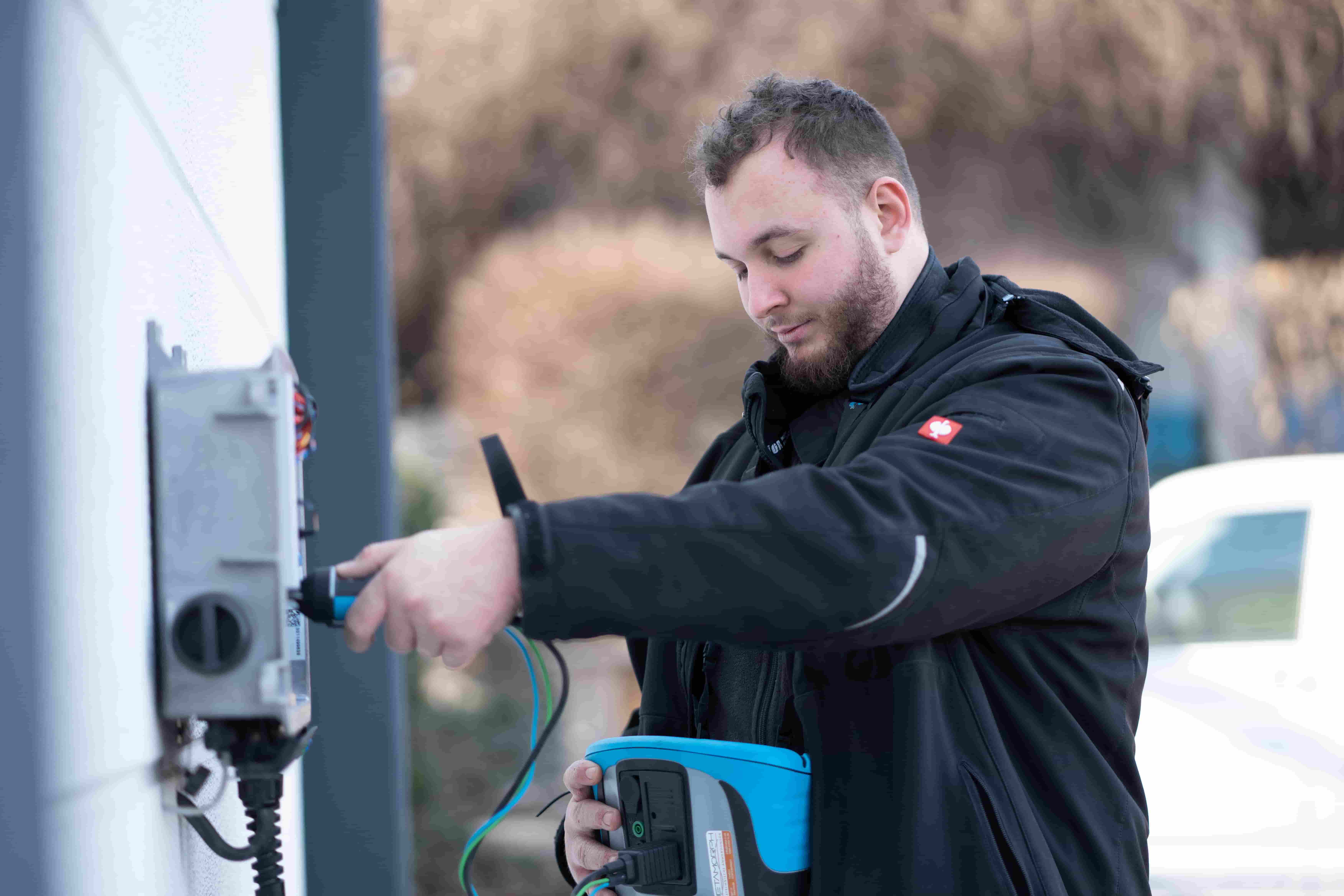Mitarbeiter von DER SOLARWART führt eine Photovoltaik-Wartung mit Messgerät an einer PV-Anlage durch.