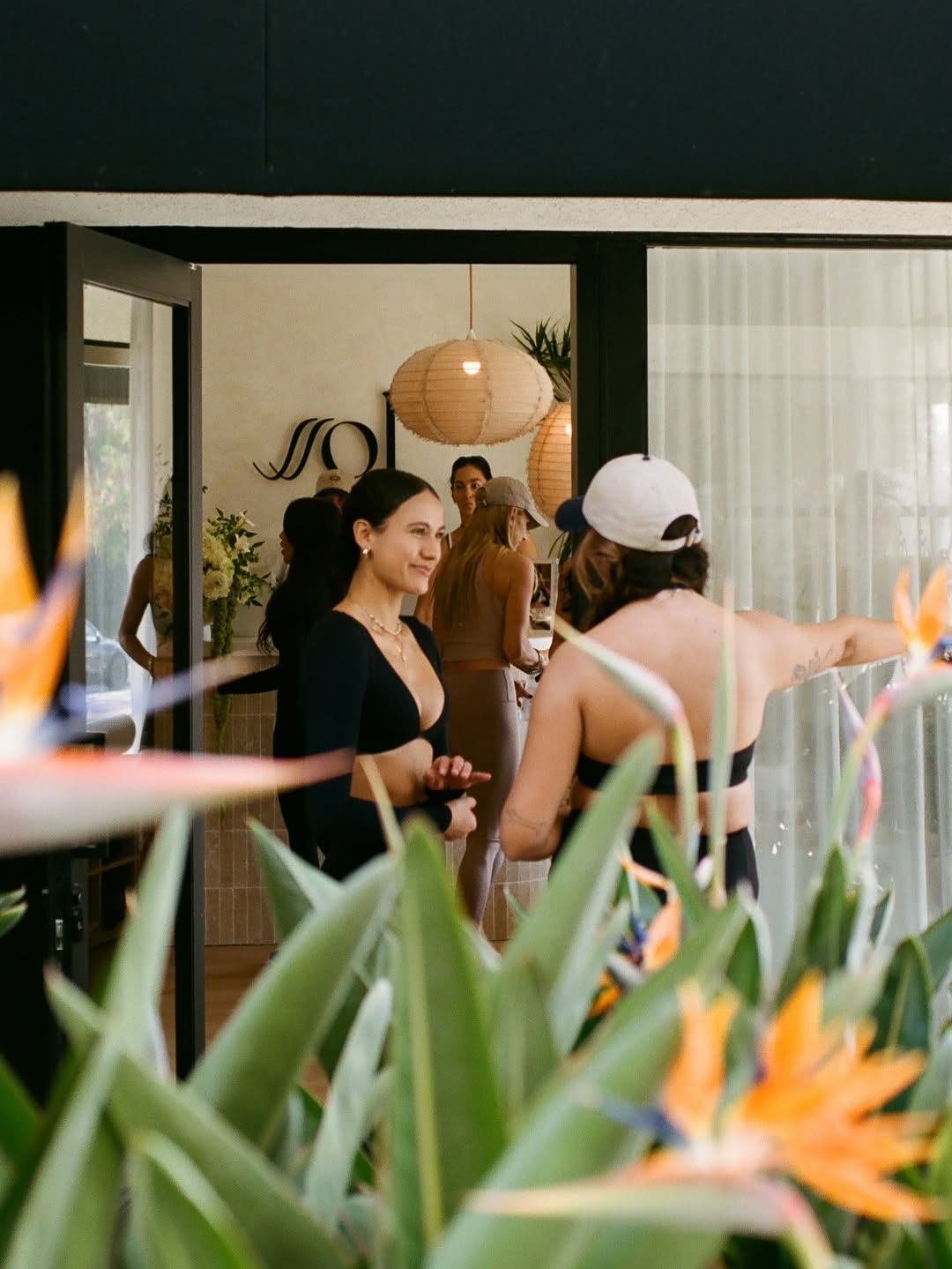 Ssol Pilates studio entrance showing members arriving and interacting within a warm, design-led space