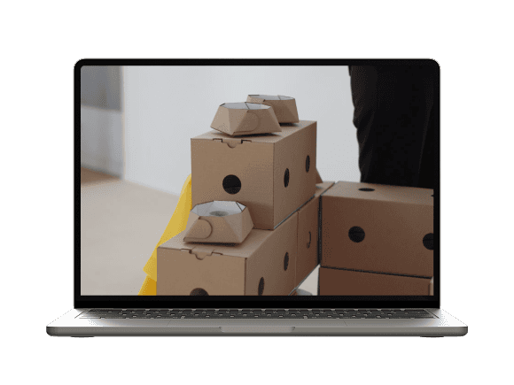 Laptop displaying modular cardboard packaging elements arranged as blocks.