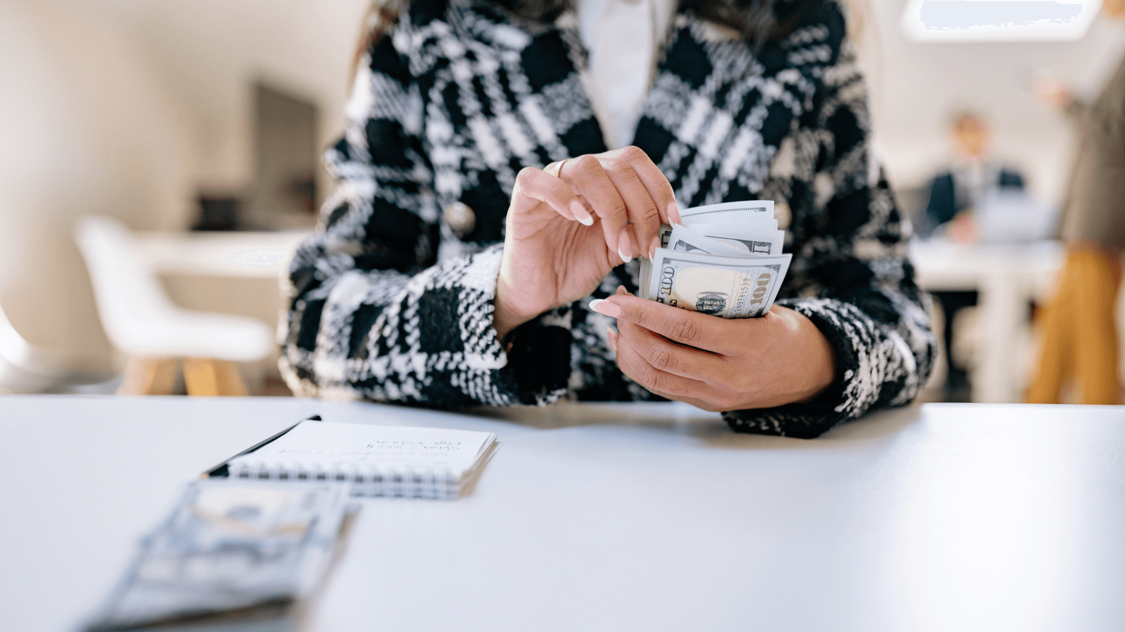 Business professional counting cash at a desk, representing payroll processing, wage payments, and payroll accuracy for growing businesses.