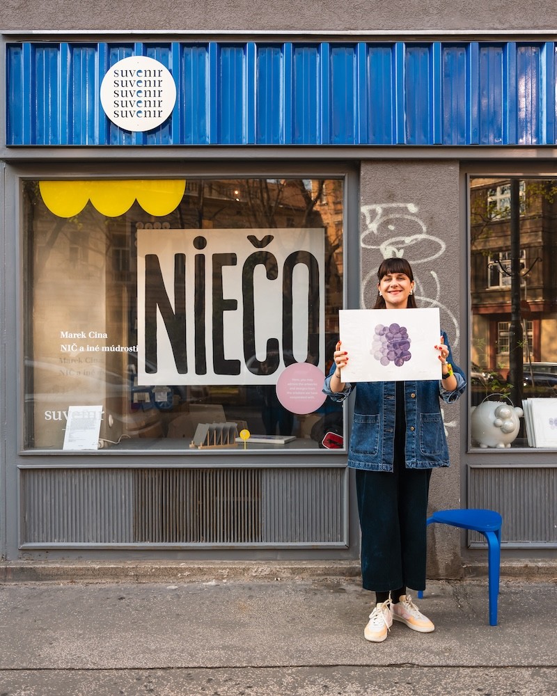 Tri grafiky BUBBLES od Niny A. Šoškovej položené na stole v interiéri shopu & café