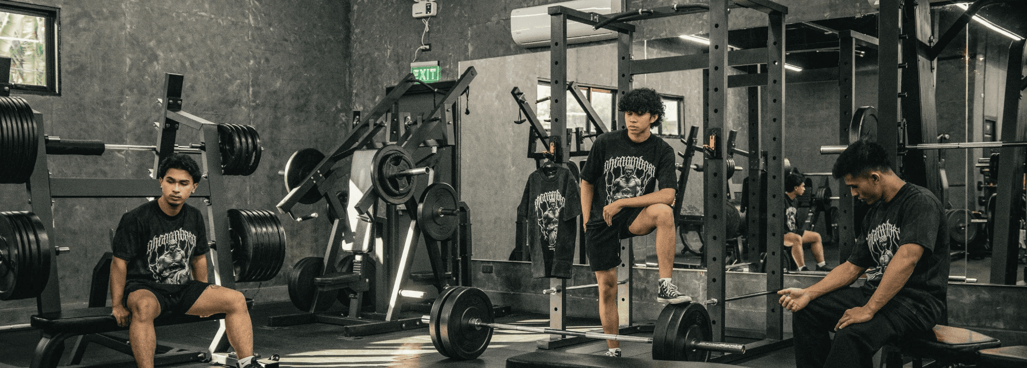 A gym scene featuring several people engaged in various workouts amidst fitness equipment.