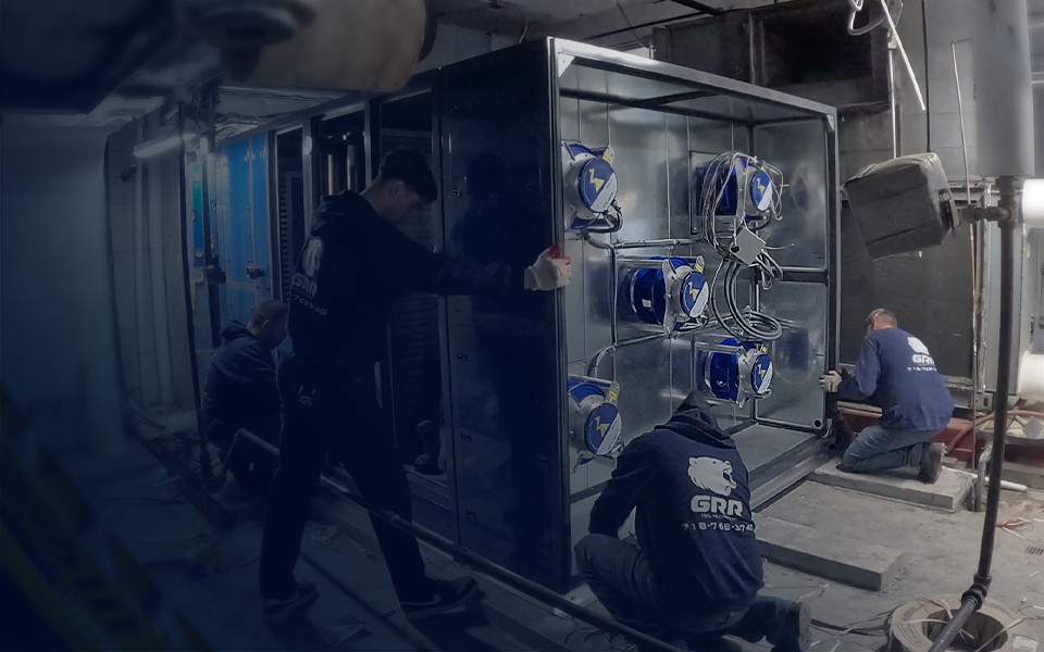 GRR Cooling Experts technicians performing HVAC retrofit and fan system upgrade inside a commercial mechanical room in New York City.