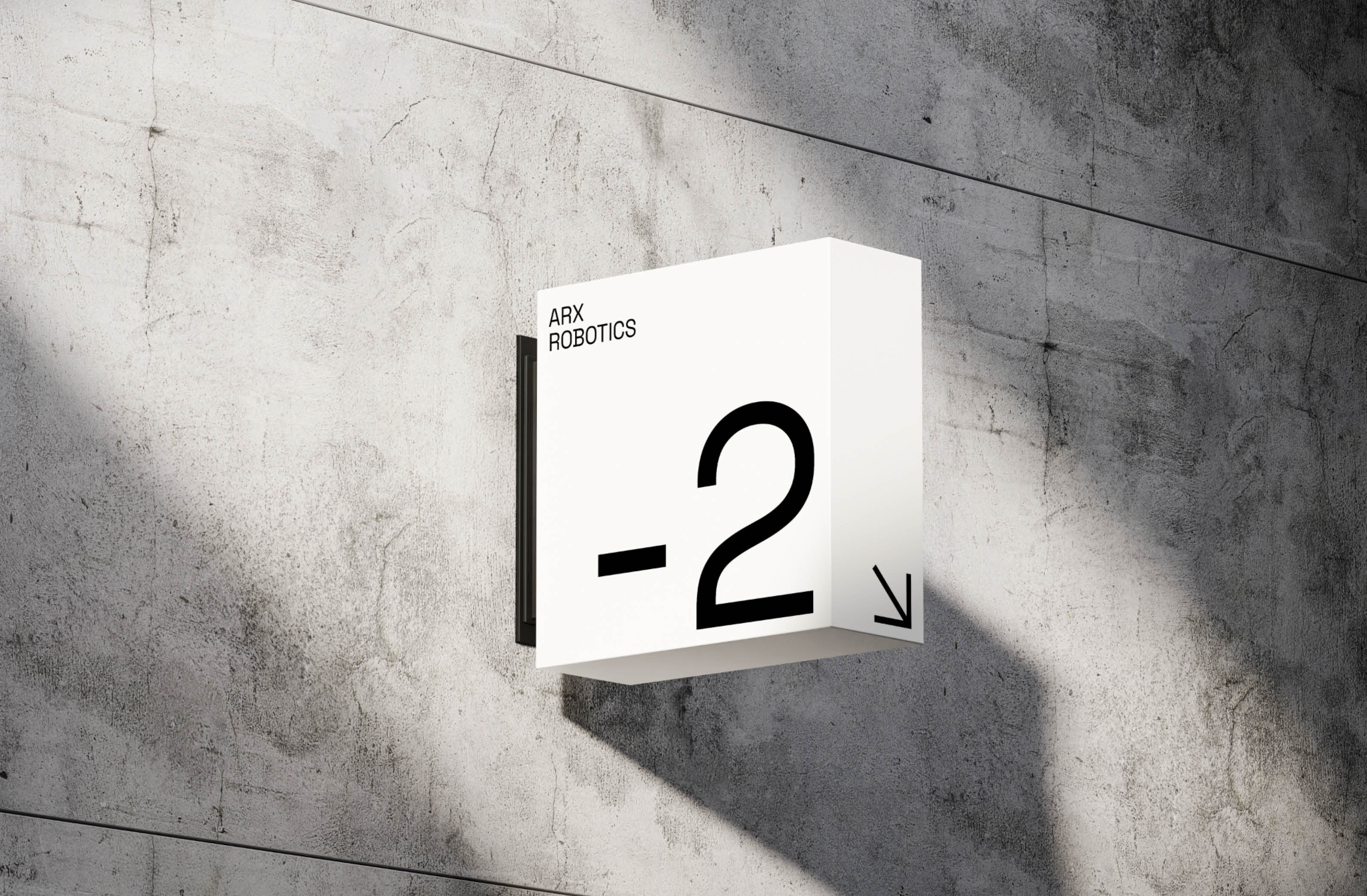Stylish directional sign indicating level -2 for ARX Robotics on a textured concrete wall.