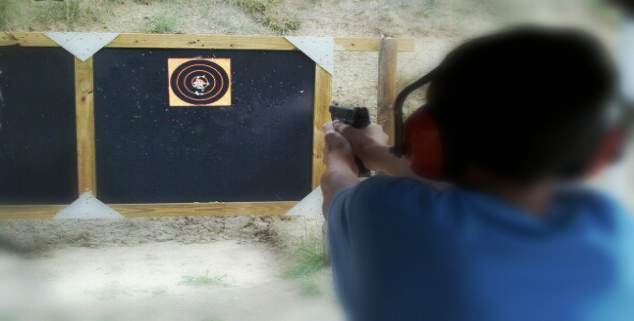 handgun shooter firing on target