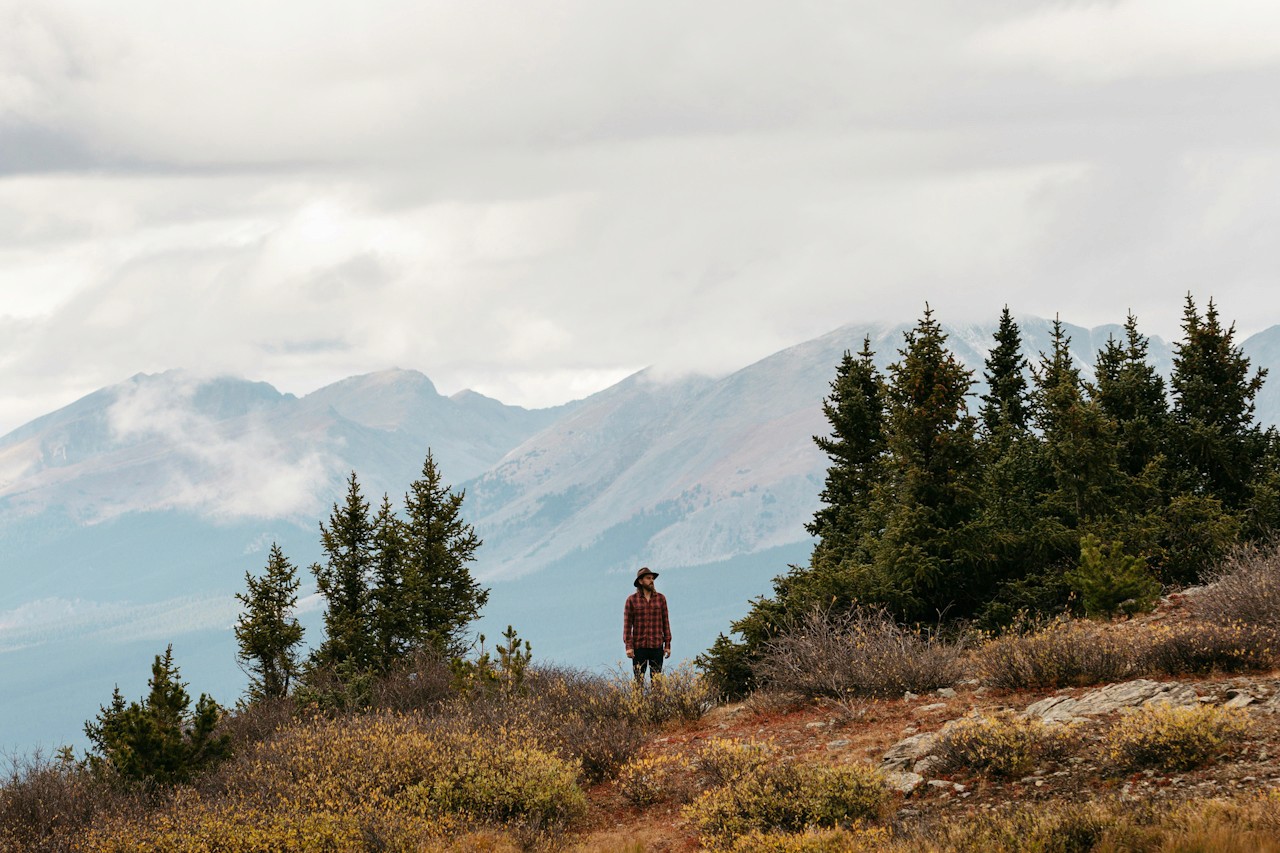 Outdoor mountain scene with person standing at the top of a mountain mood for partner Eddie Bauer