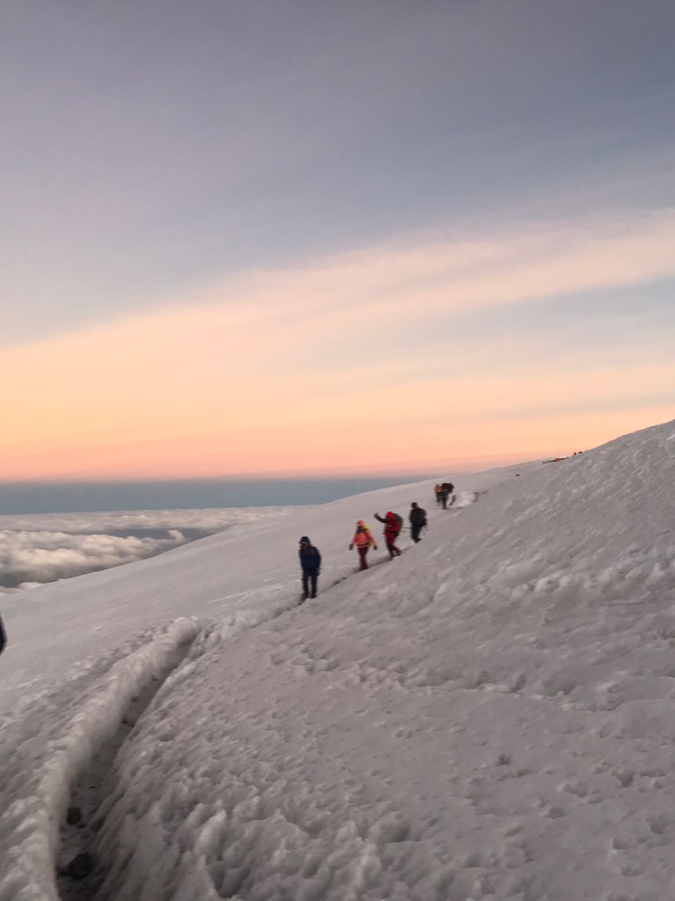 Layered desert mountains near AlUla, painted in red, beige, and orange tones under evening light.
