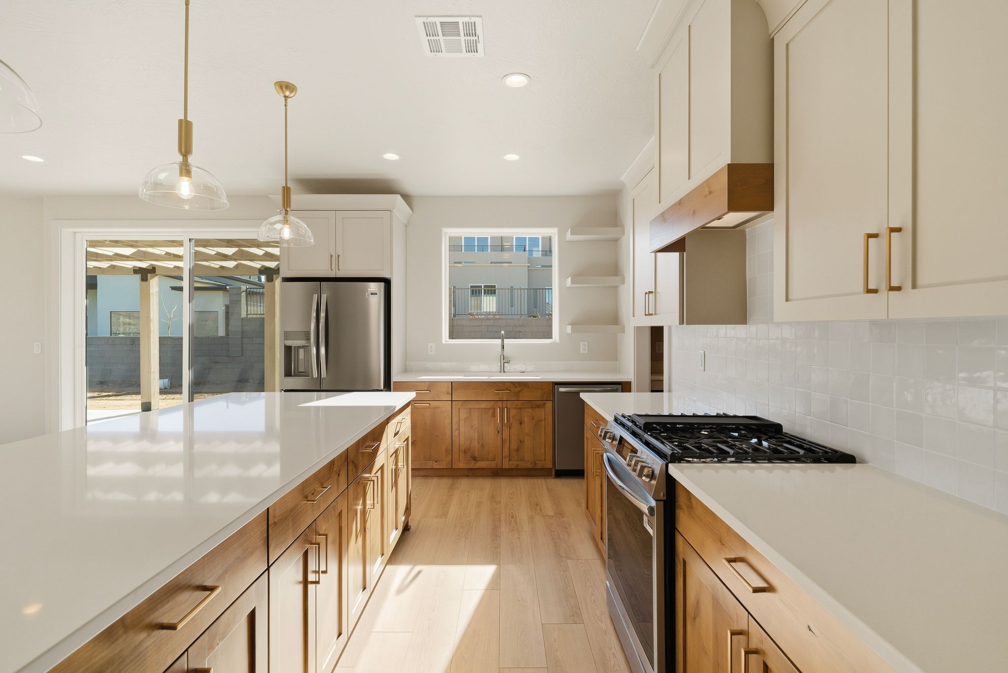 Custom kitchen at The View at Falcon Ridge in Hurricane, Utah, combining medium-toned wood cabinetry with white finishes and modern appliances.