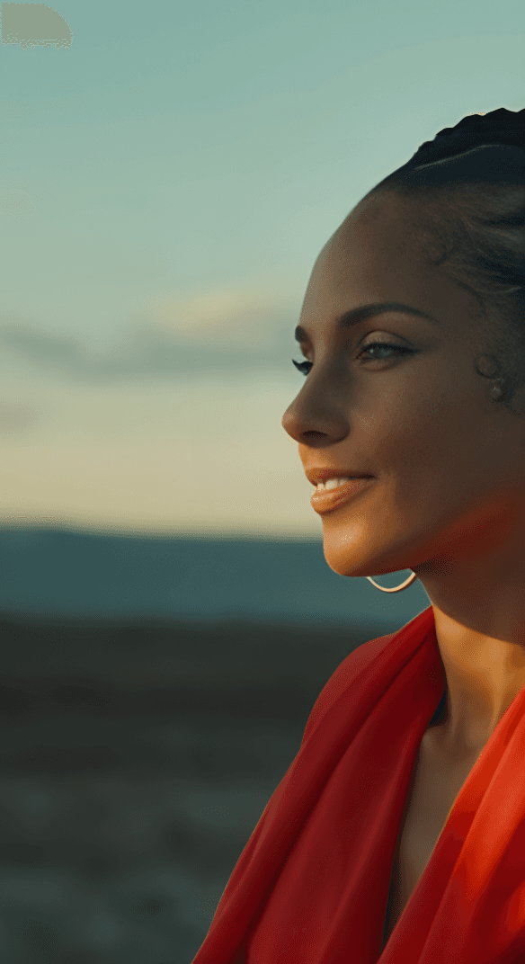 Woman with braids and earings and red shirt looking down smiling 