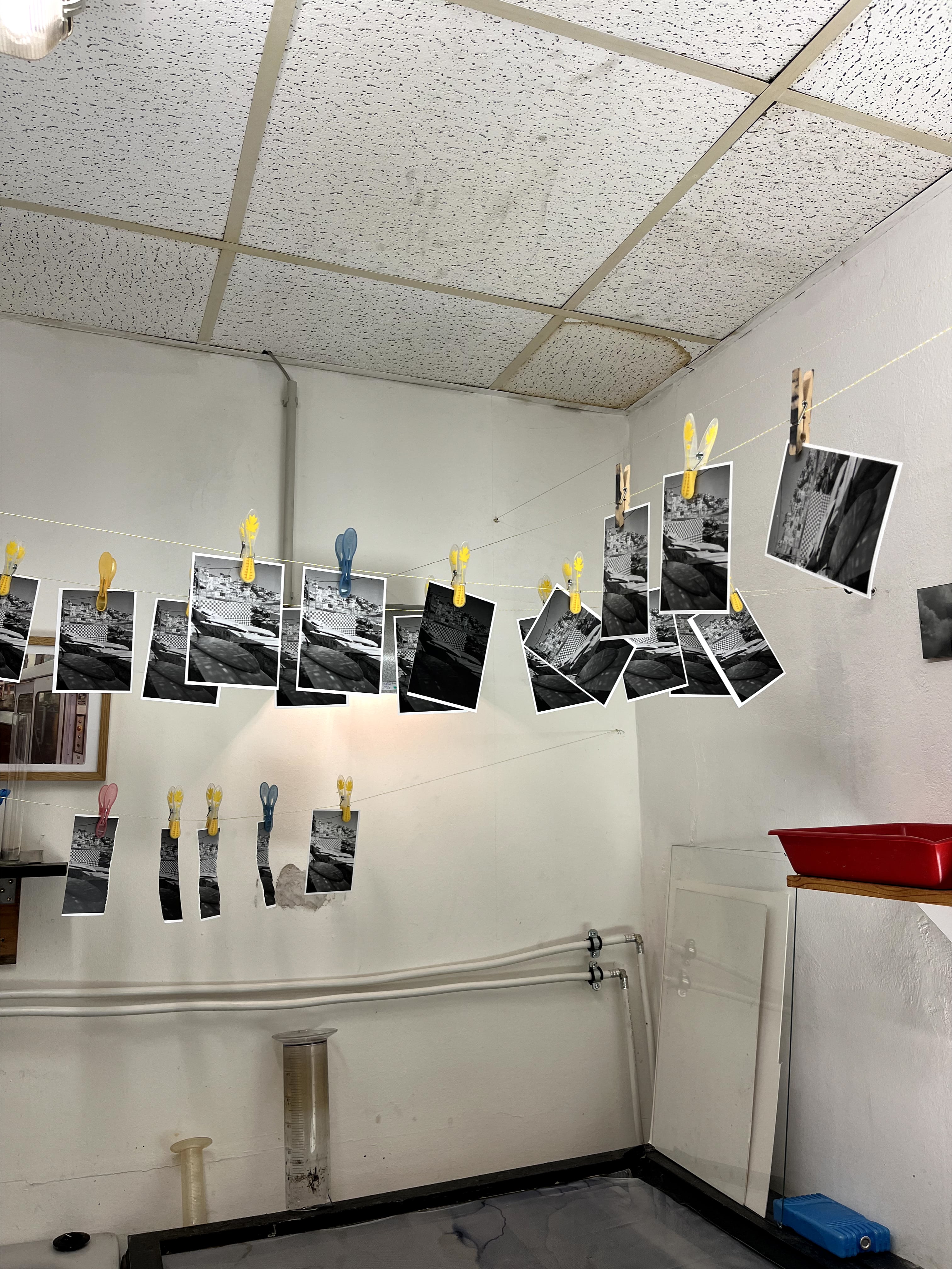 Photo of drying developed analog positives in a darkroom.