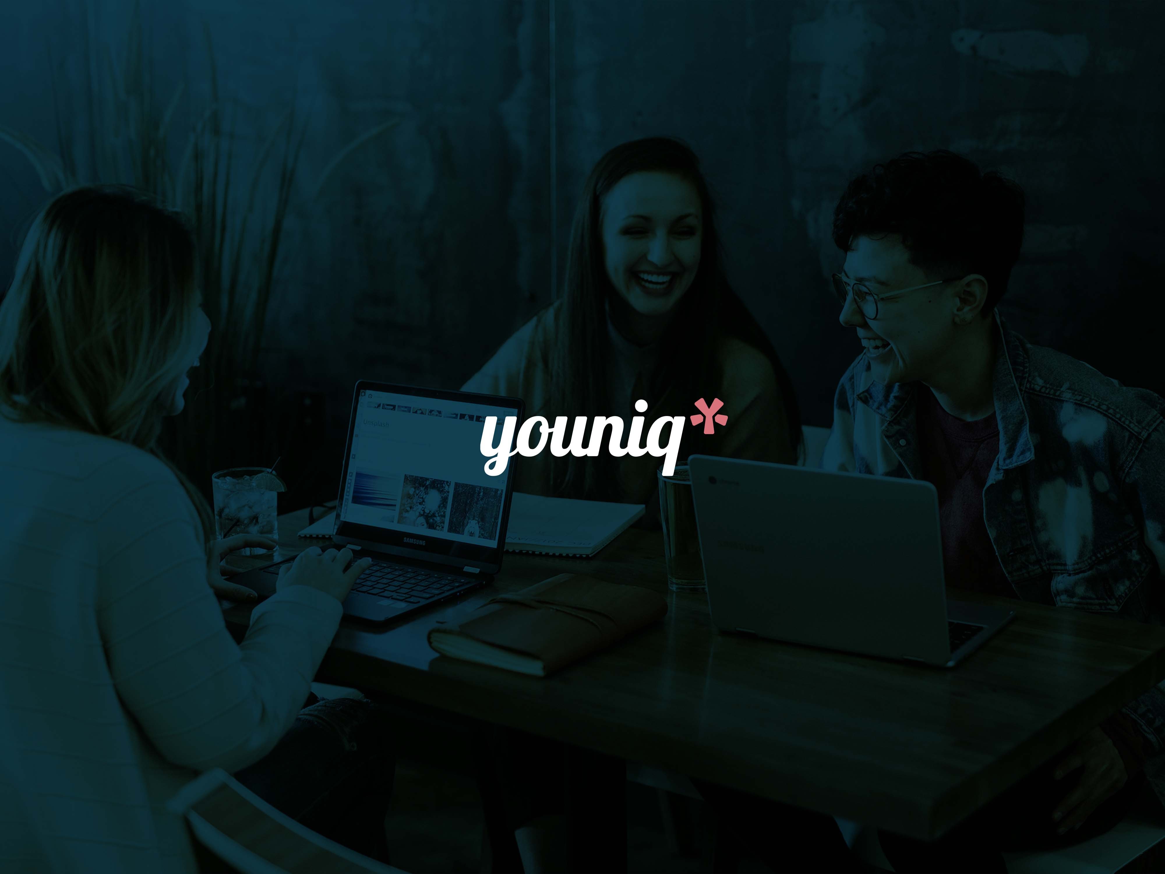 Hero image with young professionals working together and the logo overlay - Youniq, a recruitment brand identity.
