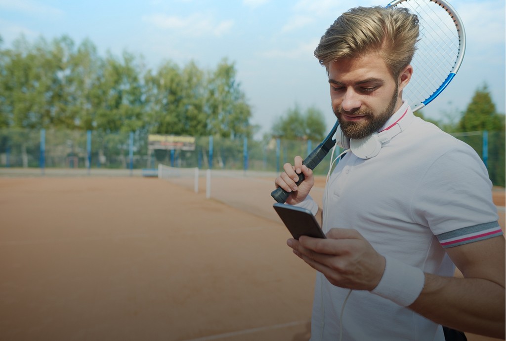 Tennis player reviewing stroke analysis on phone, available for clients remotely or on-court in United States