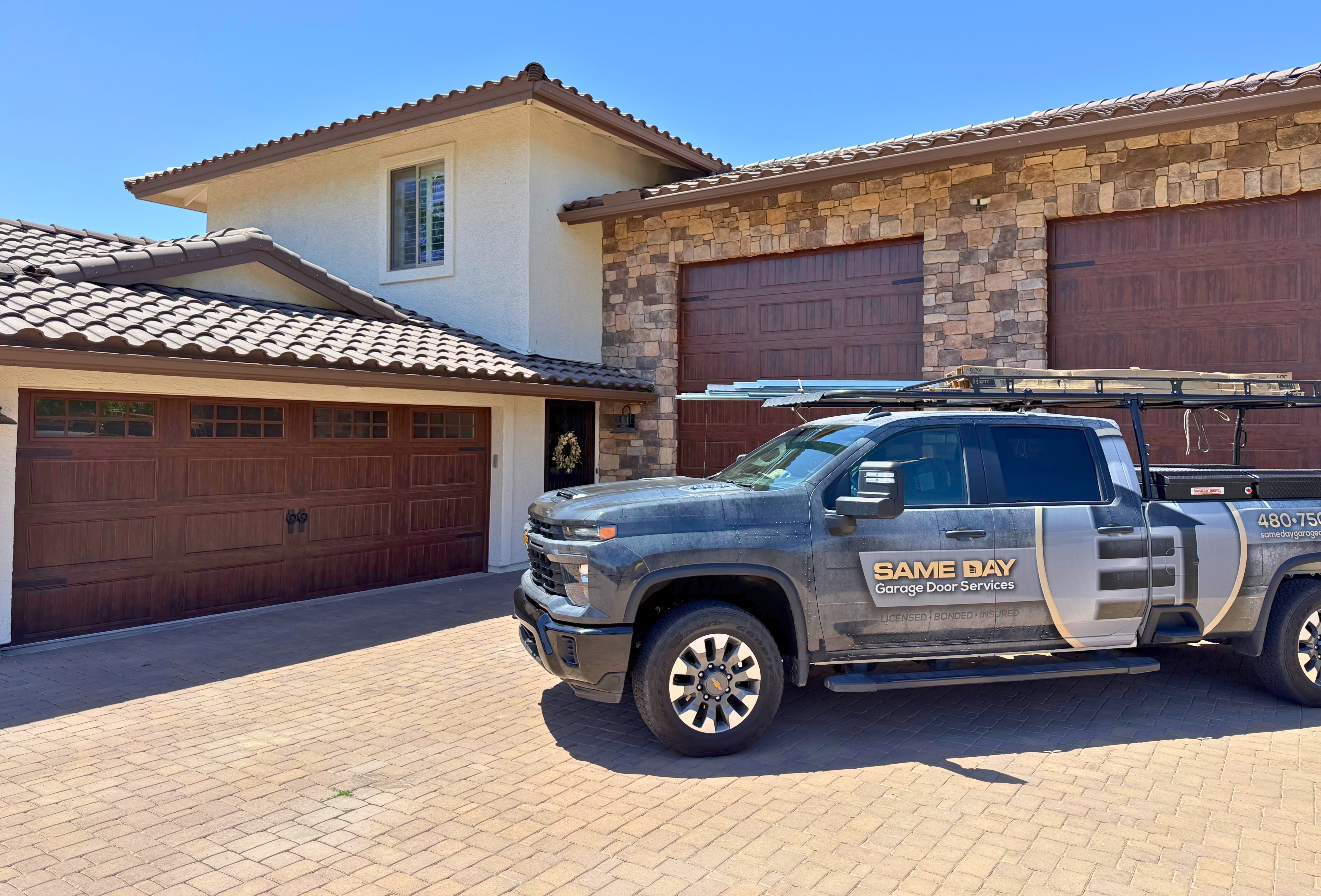 Same Day Garage Door Services service truck outside freshly installed garage doors at a local phoenix residence