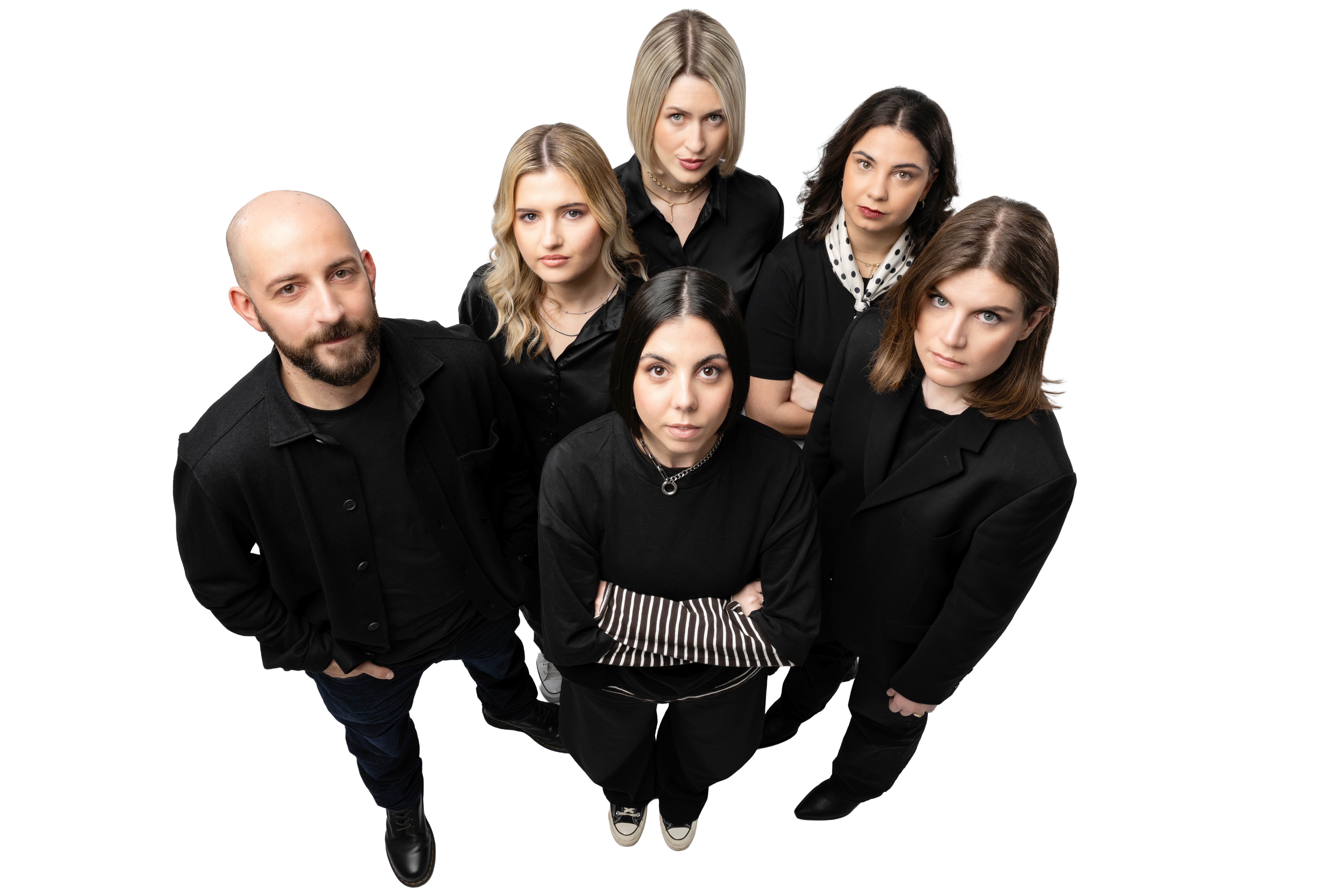Black and white image of people working at a table with laptops, showing hands gesturing during discussion of digital content displayed on screens, with fabrica® logo in the corner.