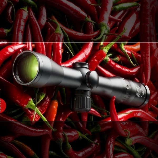 Im Gewirr roter Chilischoten ruht ein Zielfernrohr von Karl Kaps.