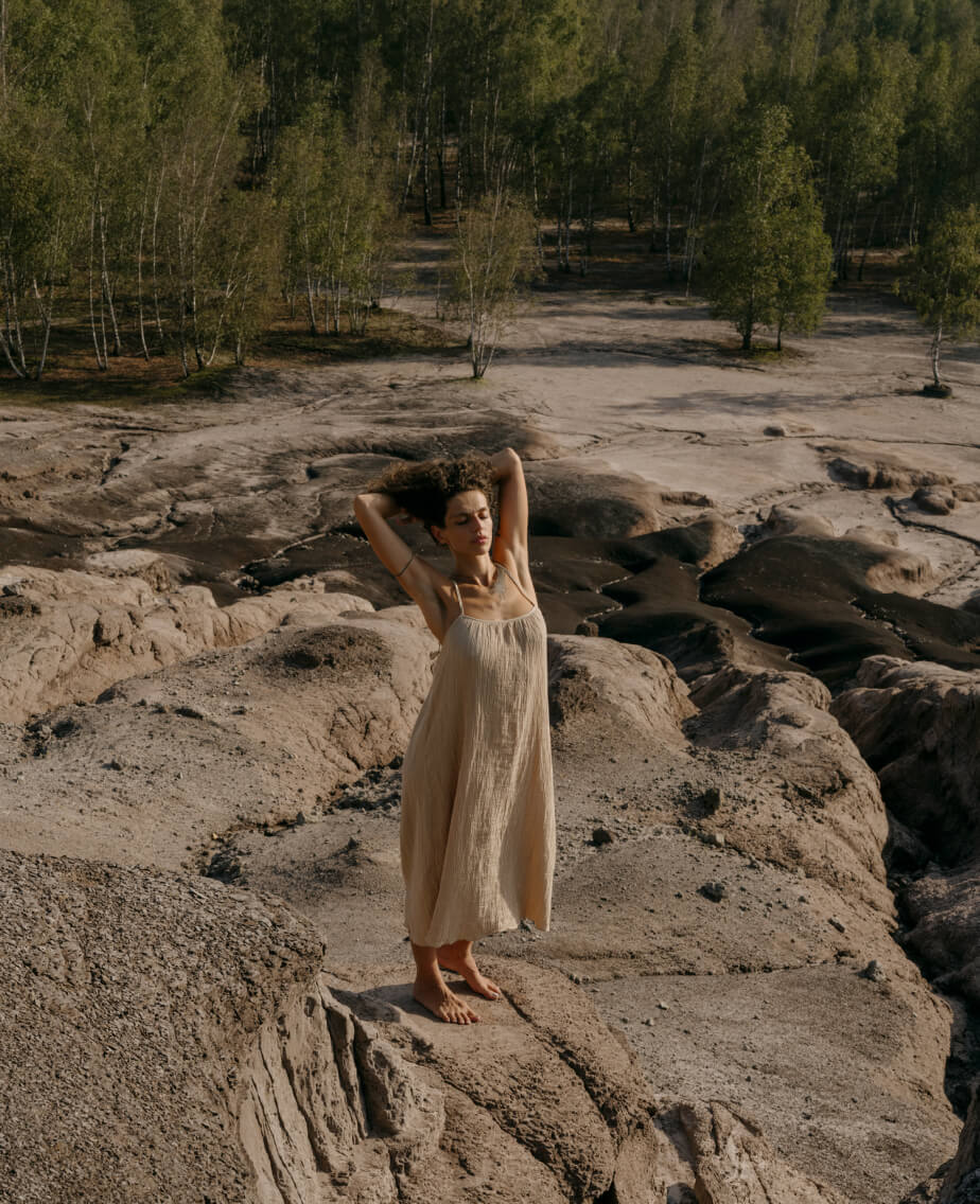 Blertë Dibrani posiert mit beigem Kleid auf einem Felsen