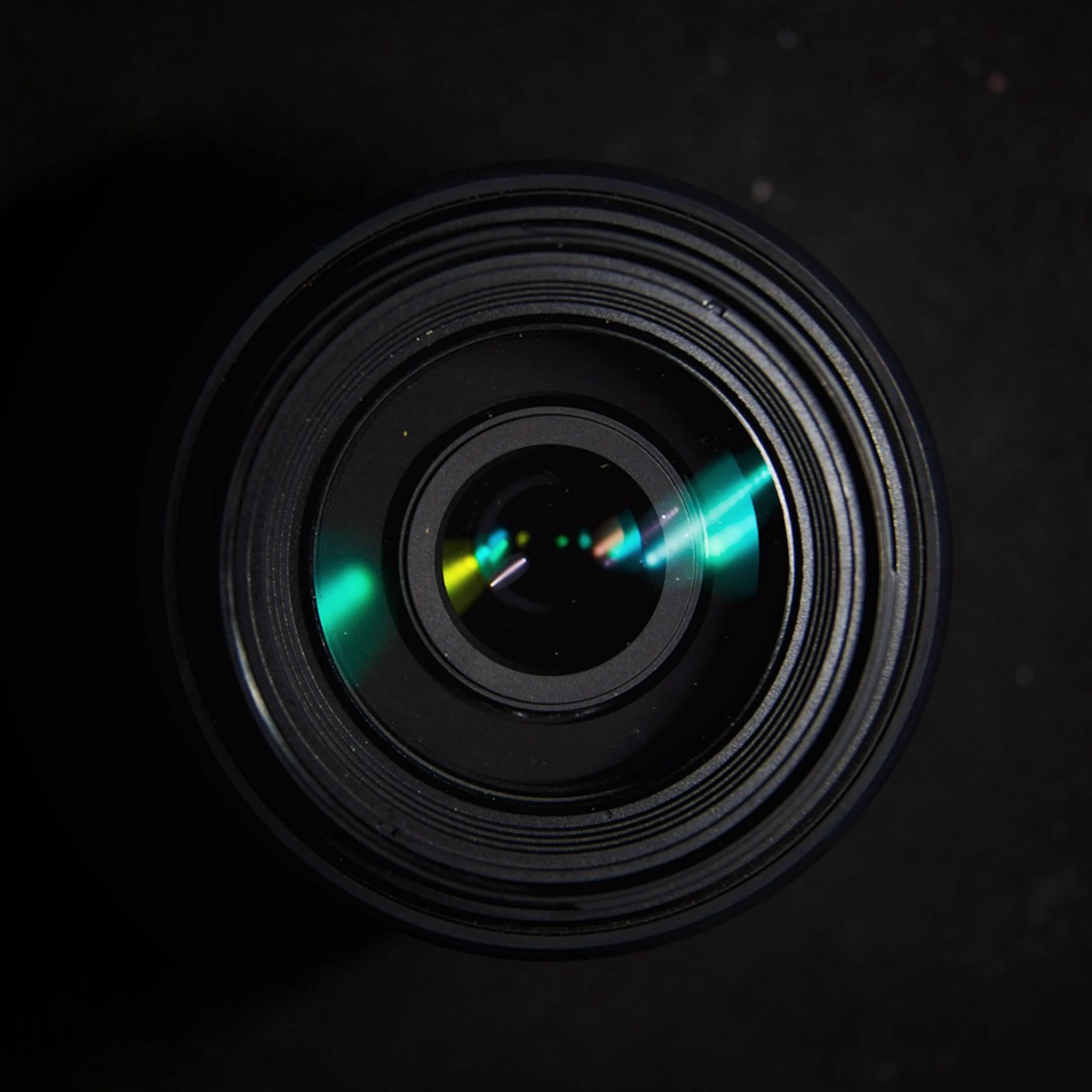 Macro shot of a camera lens with a colorful light reflection