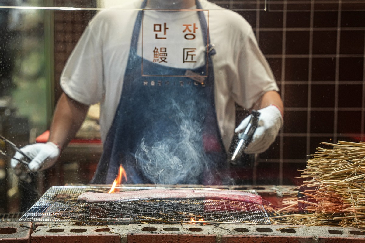 볏짚을 태워 장어에 훈연 향을 입히는 만장의 마무리 과정