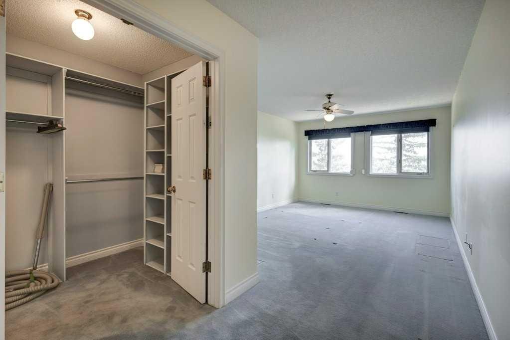 Strathcona primary bedroom before: open closet and worn carpet