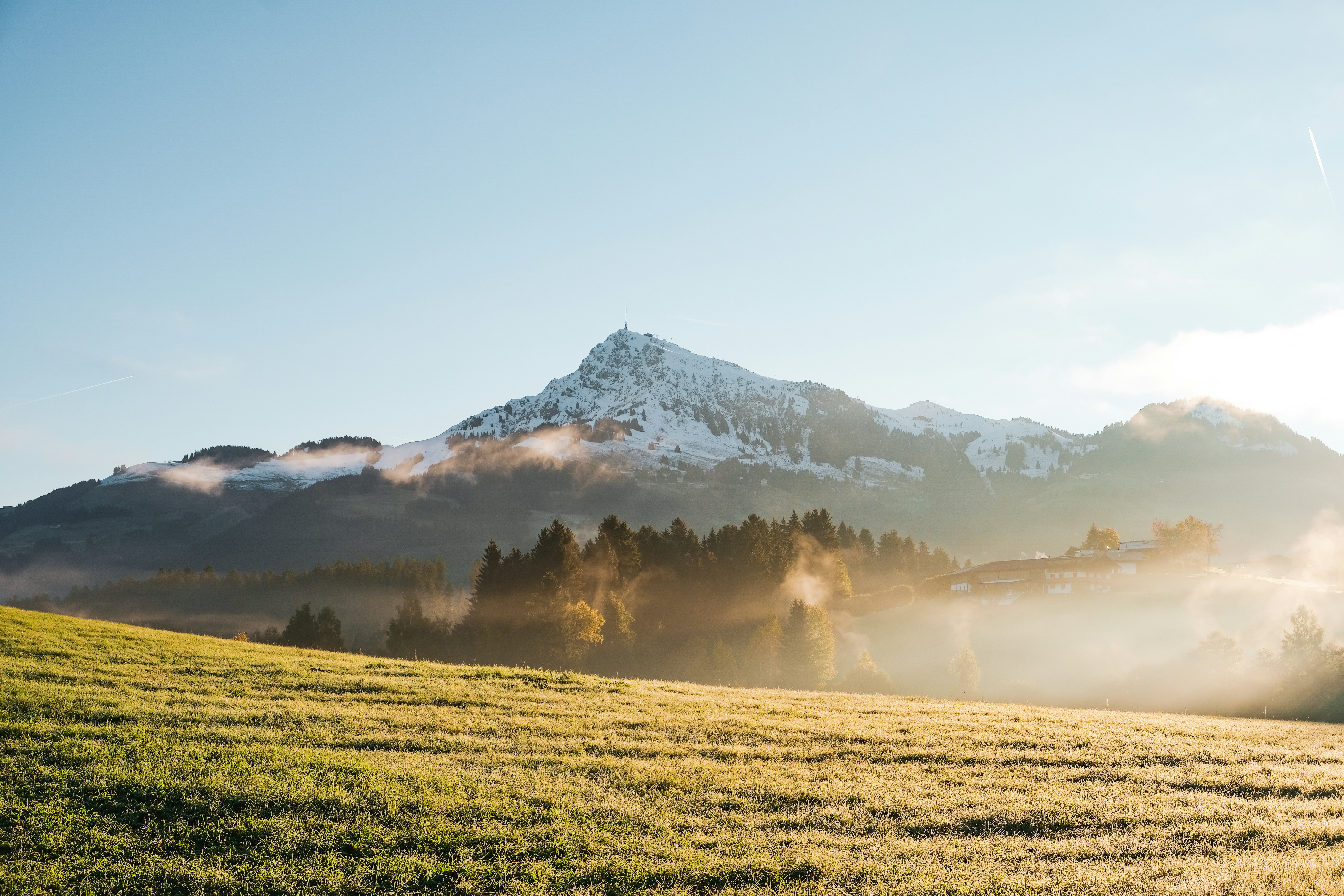 Sonnenaufgang über nebelverhangenen Wiesen und Berggipfeln – friedliche Morgenstimmung in den Tiroler Alpen.