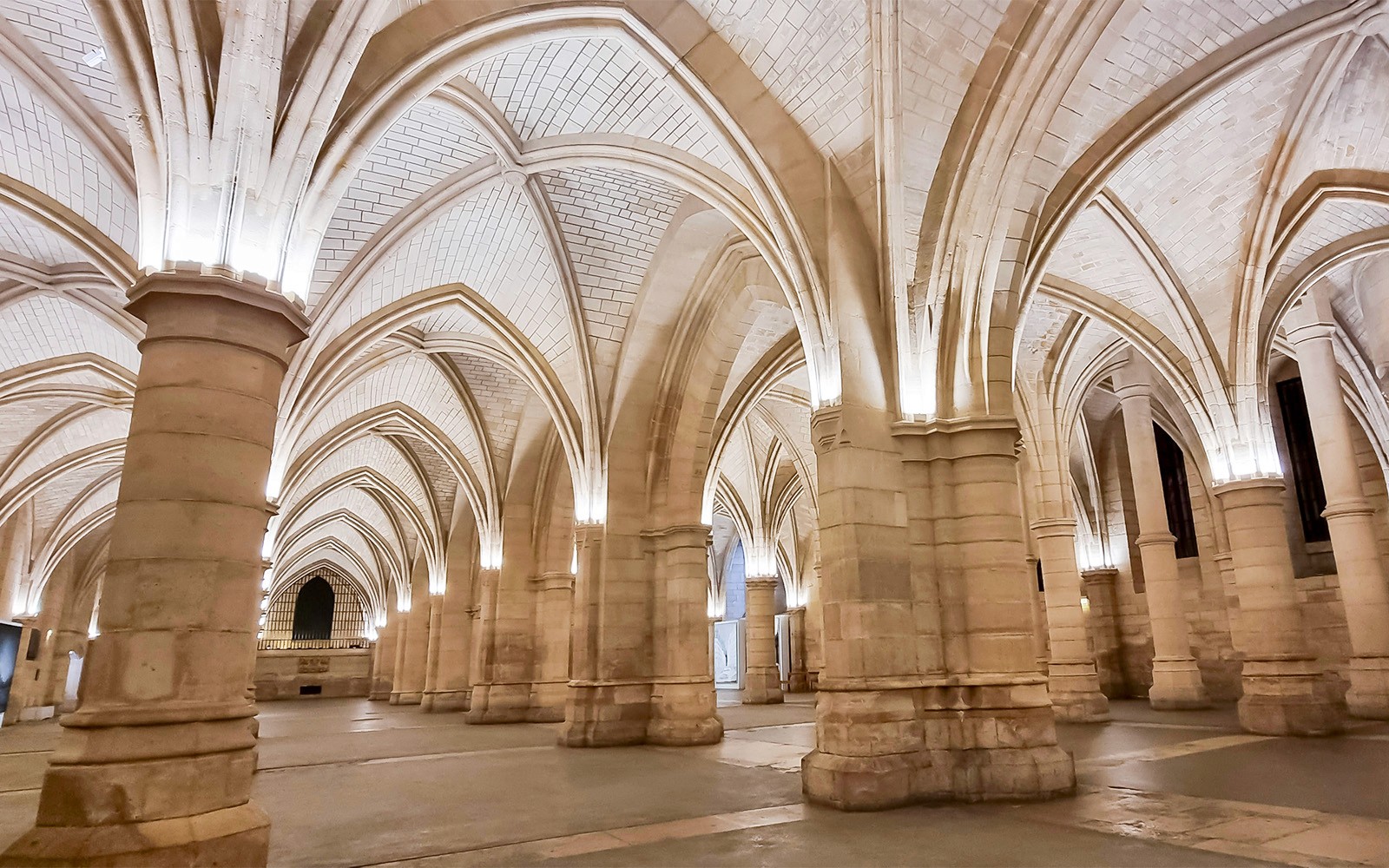 Interno della Conciergerie con soffitti a volta e colonne di pietra a Parigi.