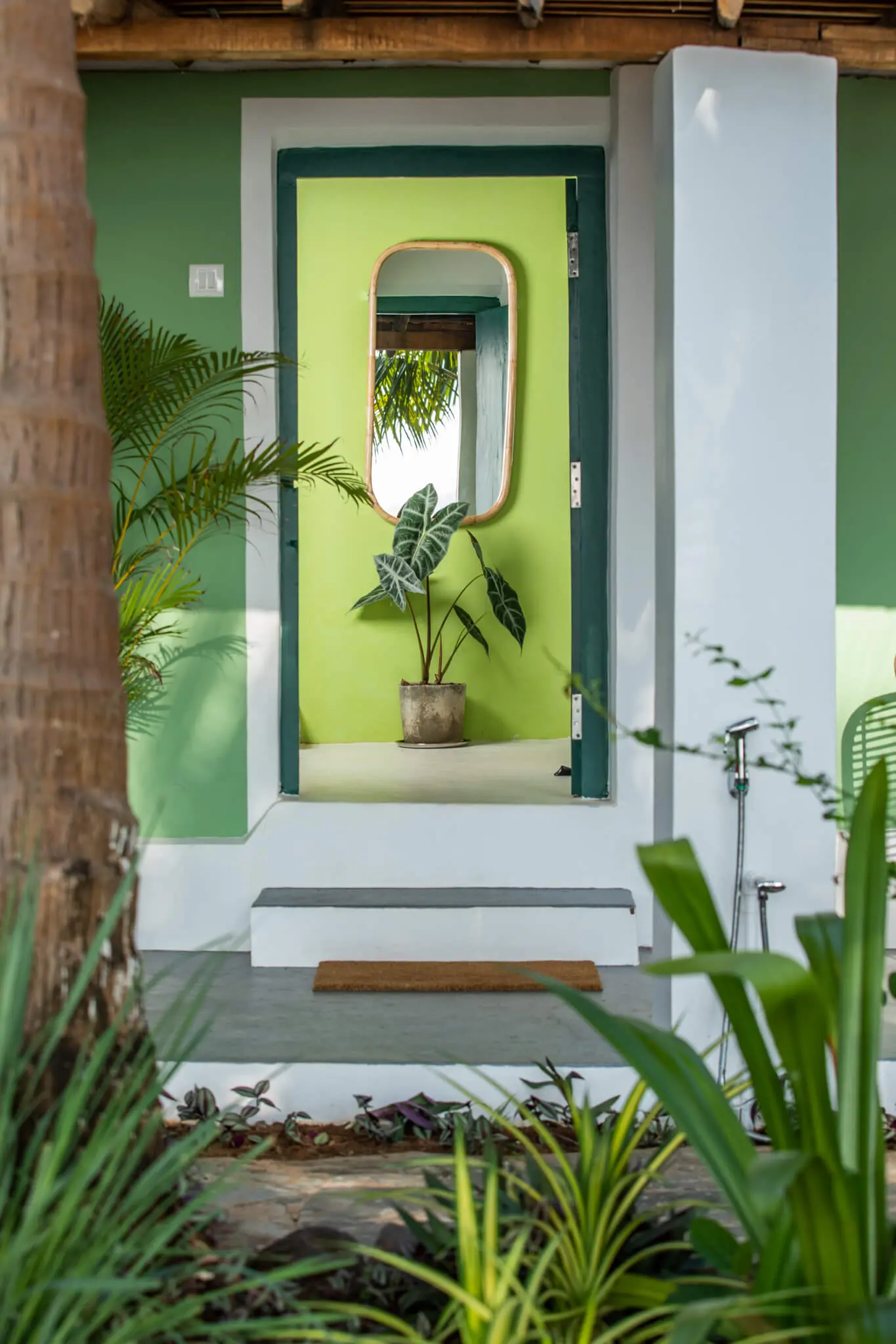 Sea View Family Room at Casa Jaali — green entry door with cane mirror