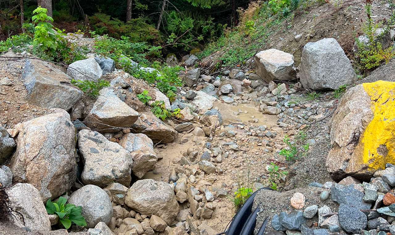 Rock armored drainage channel with natural revegetation at Statlu aggregate extraction site