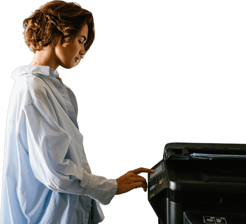 Woman standing at a printer.