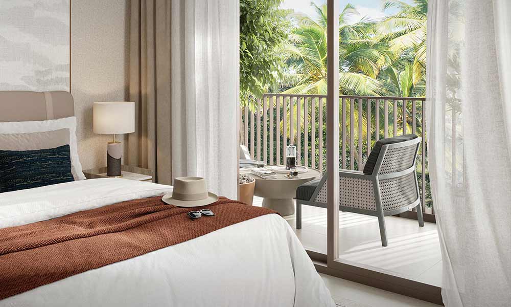 A stylish bedroom with a balcony offering a stunning view of the ocean at Moor by Emaar.