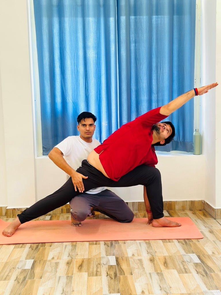 yoga teacher helping student