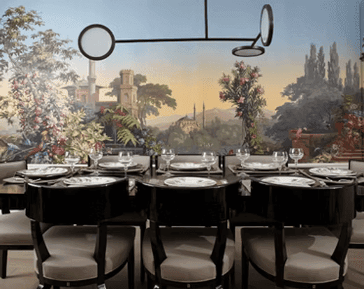 A person with short blonde hair holds a vintage camera.