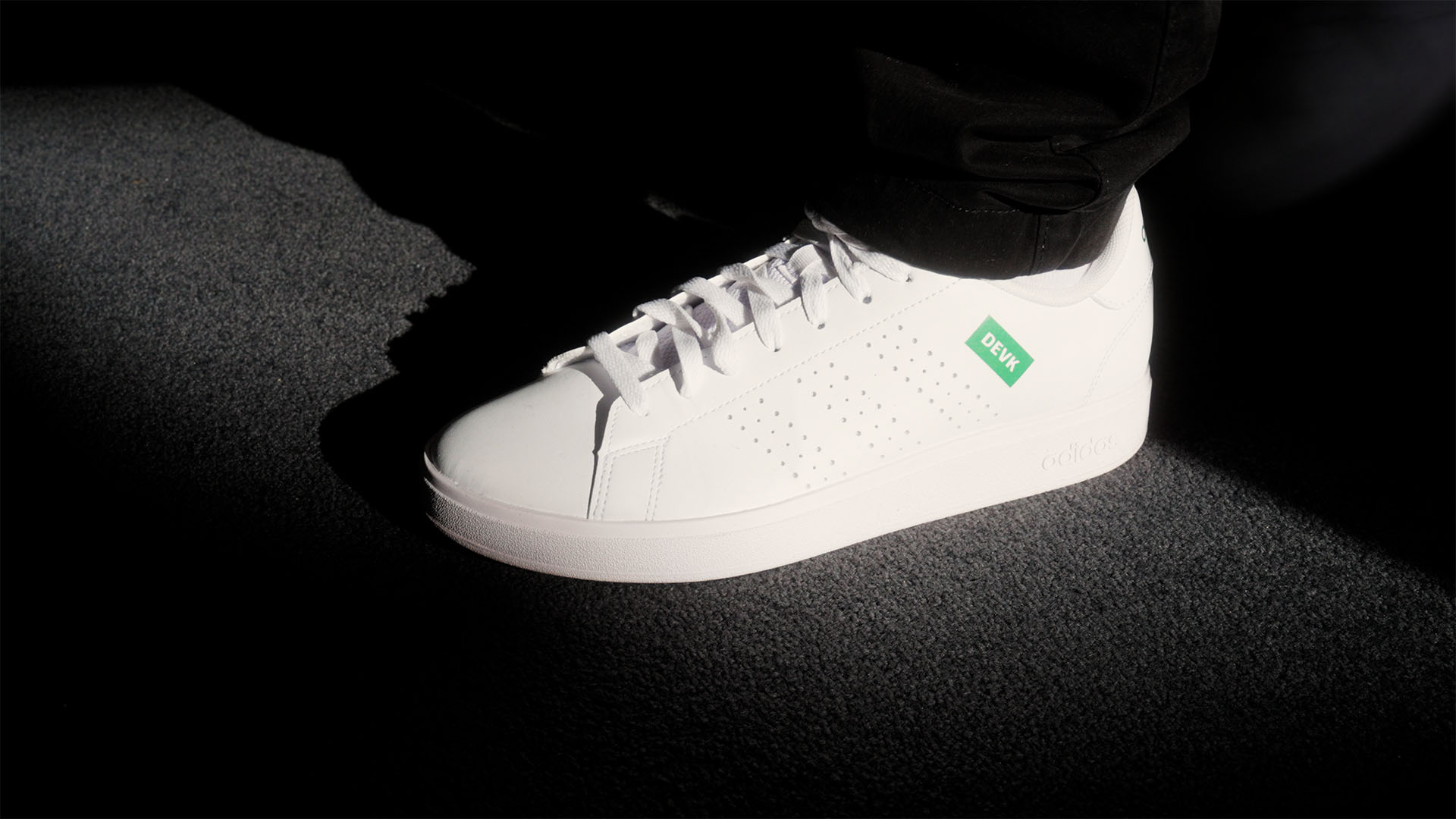 White sneaker on dark carpet, highlighting strategic filmproduction for ads and social media campaigns in brand storytelling.