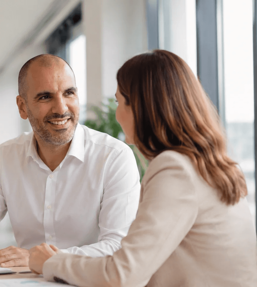 Échange professionnel entre un consultant AOY Conseil et une dirigeante de PME dans un bureau lumineux.