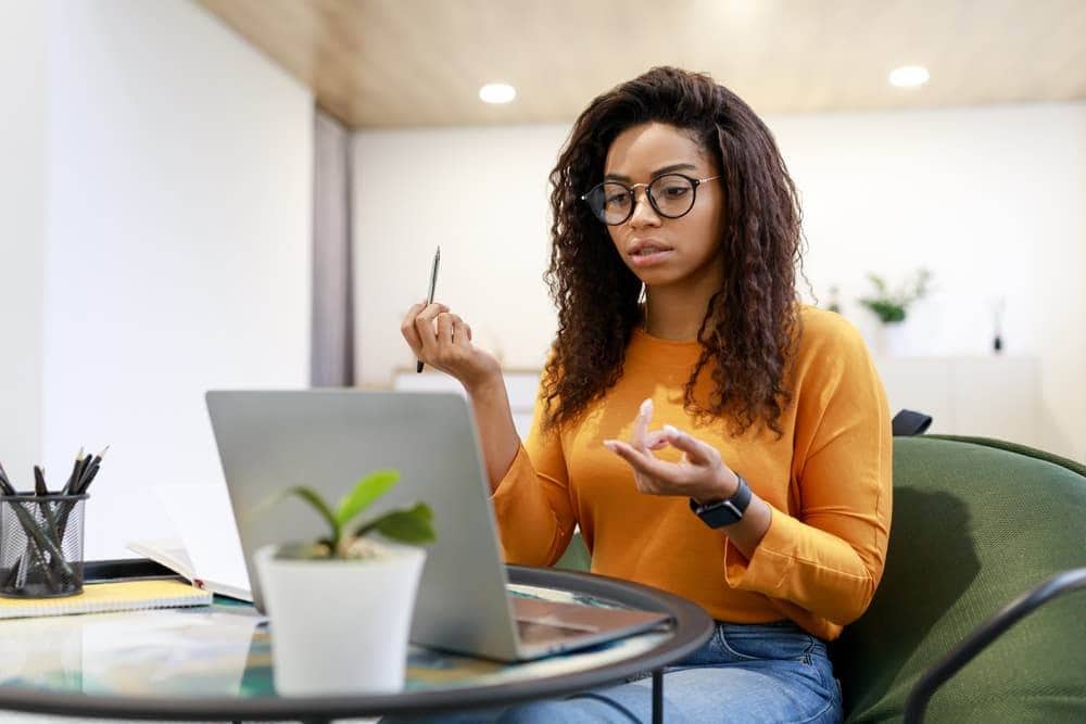 A businesswoman takes a video call on her laptop