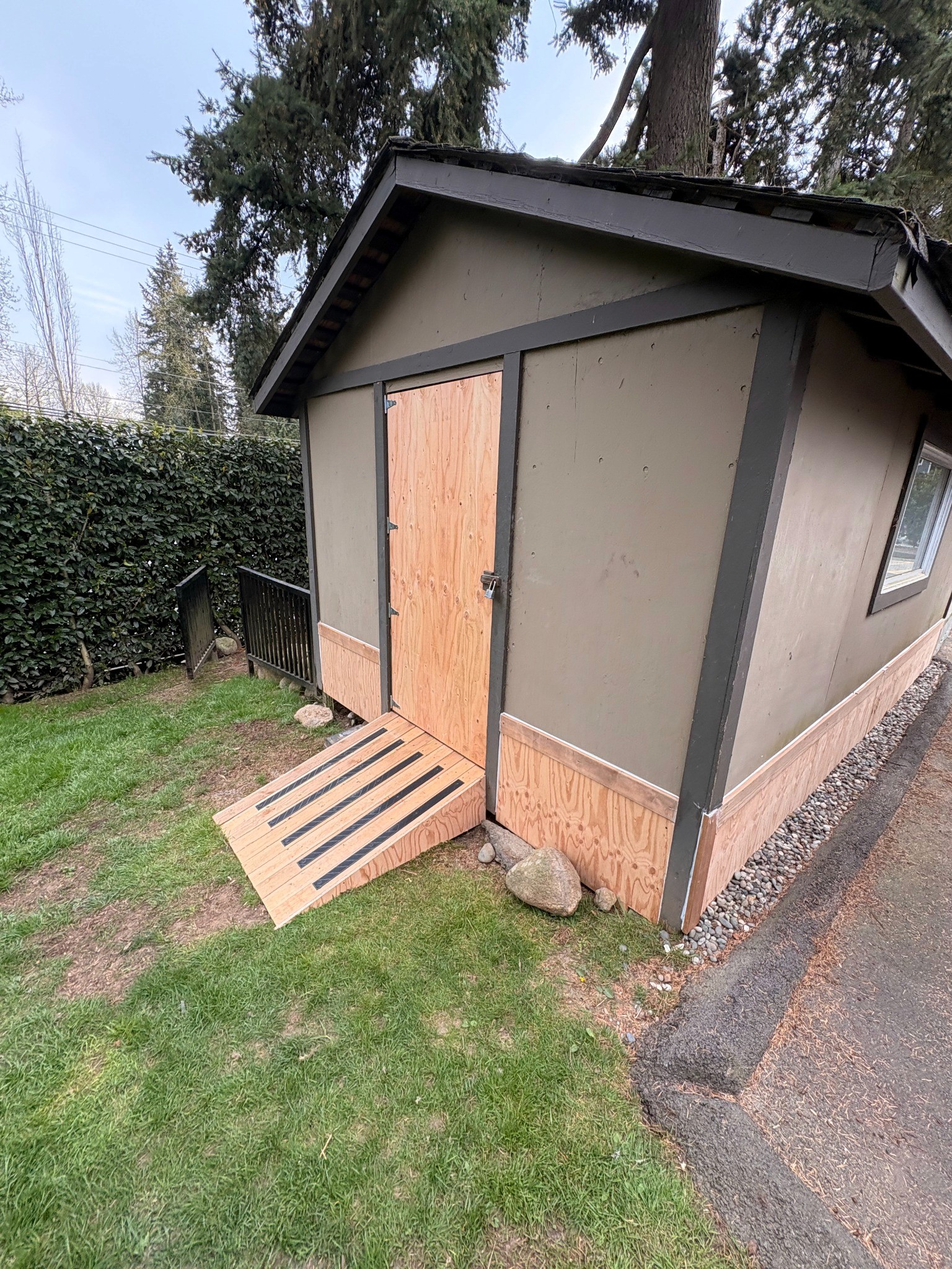 Completed outbuilding restoration showing repaired exterior walls, new entrance door and rebuilt access ramp.