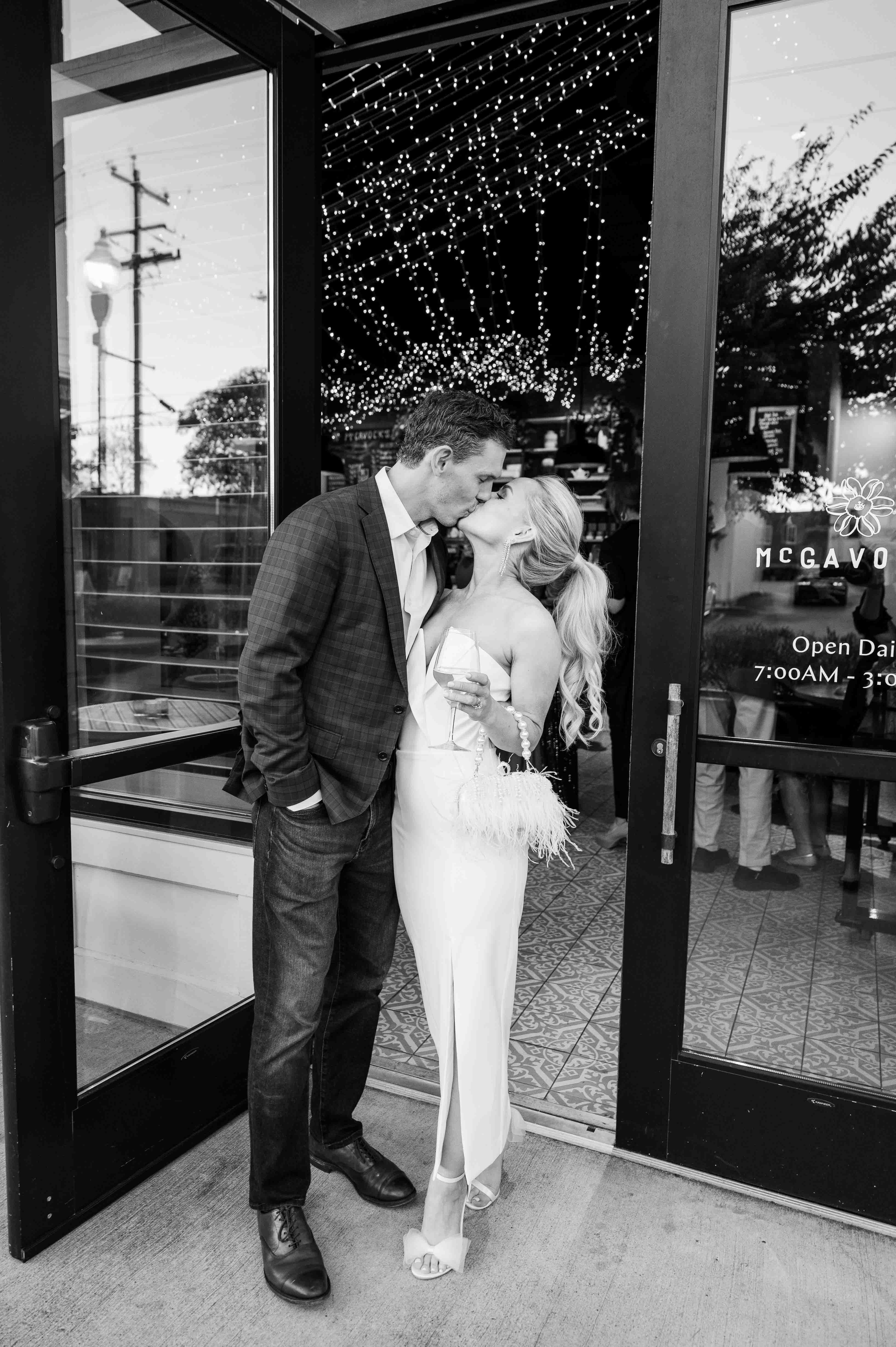 Black and white image of bride and groom kissing.