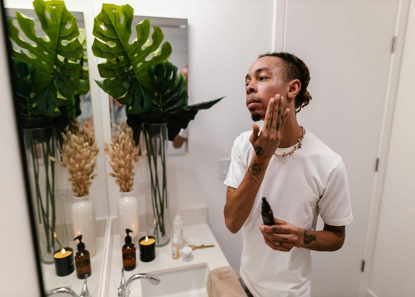 How to Apply Minoxidil - man moisturizing his face in a mirror