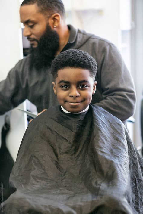 Le coiffeur avec son client un enfant en train de se faire coiffer