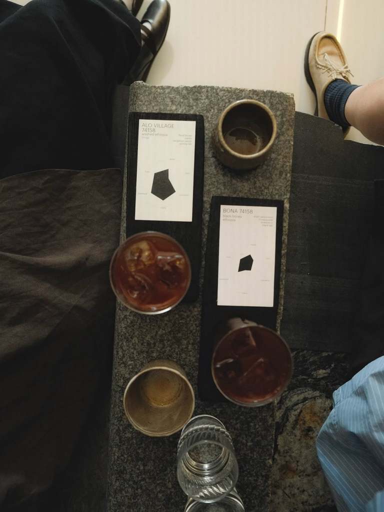 Overhead view of a table with two drinks, glasses, and menus detailing 'Alo Village' and 'Biona.'