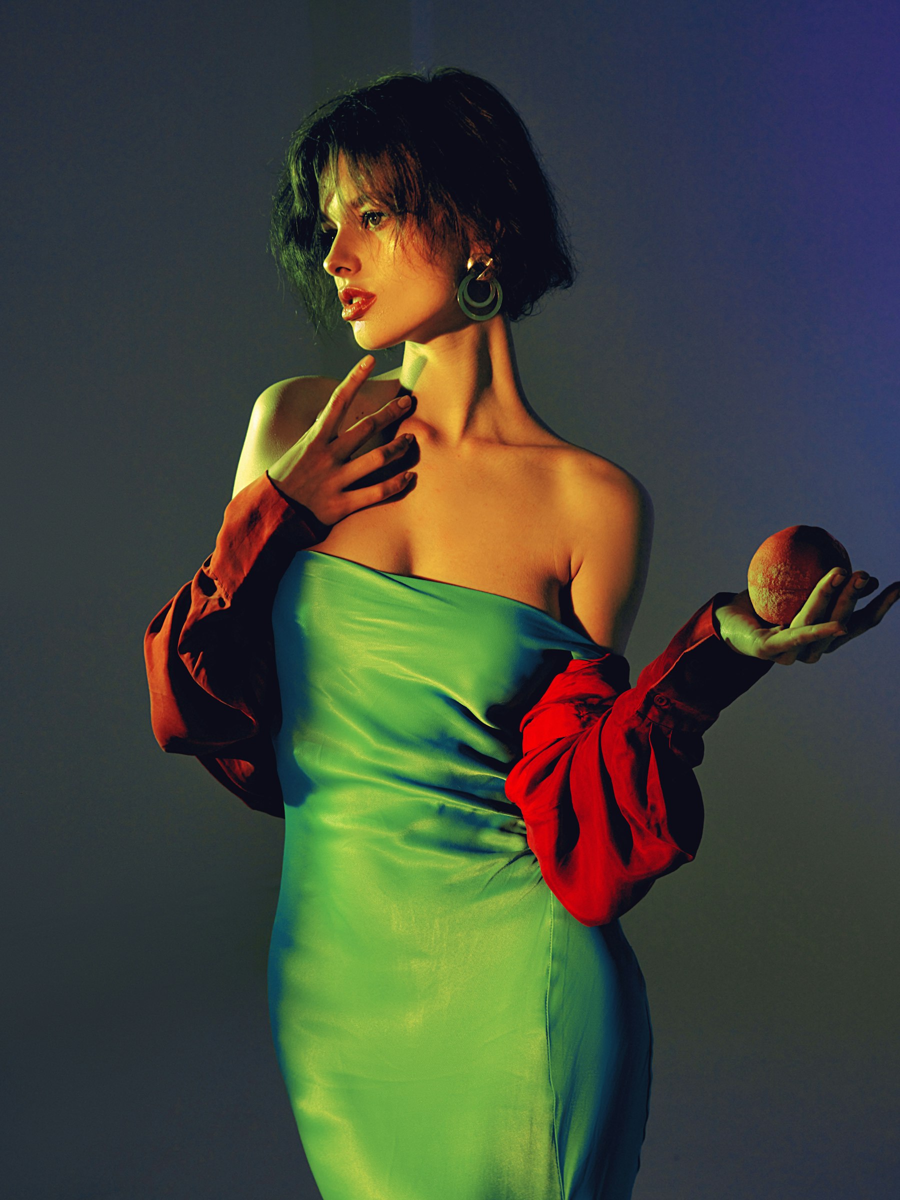 Green silk and a red sleeve on a deep blue backdrop