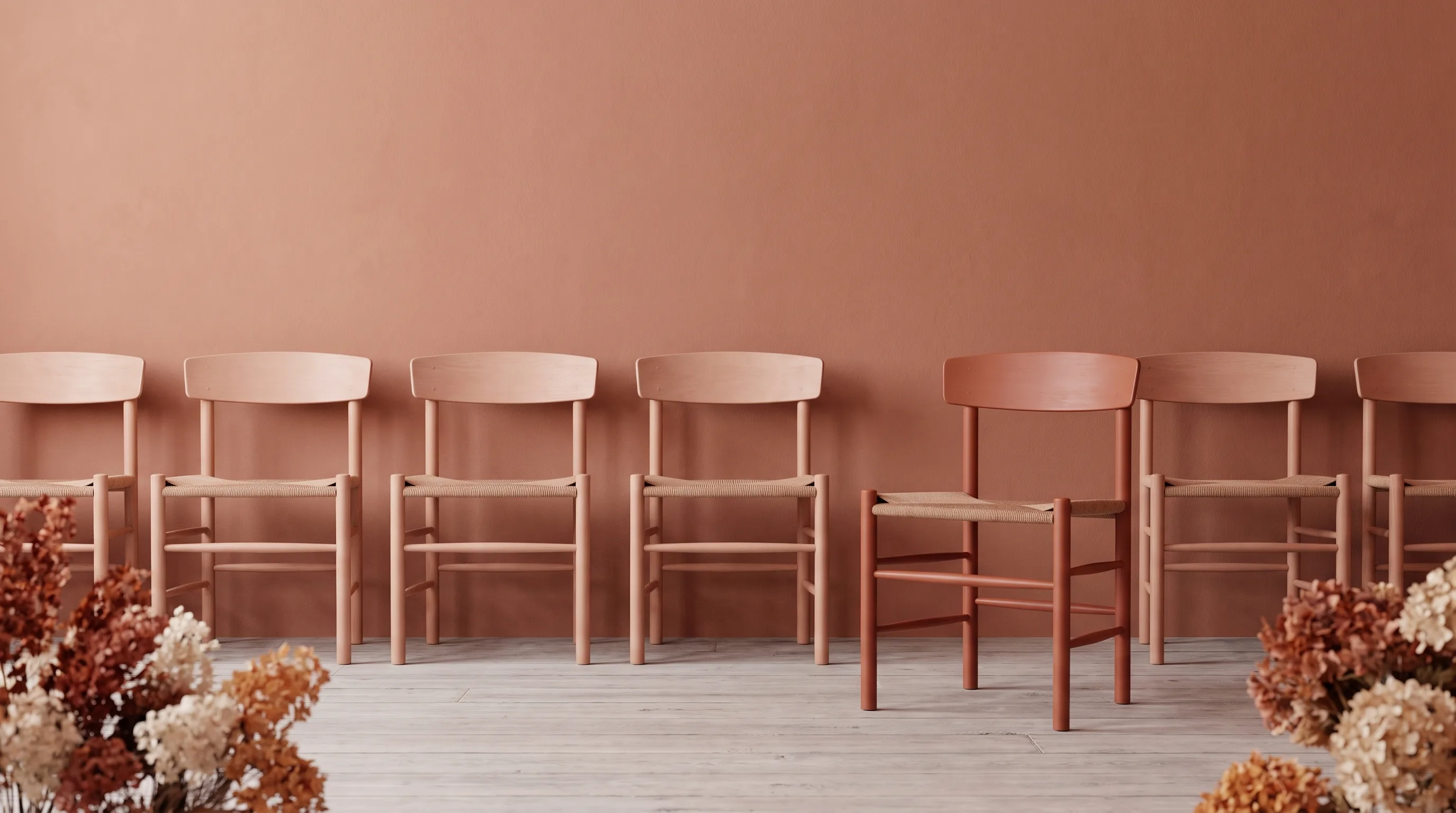 A row of matching chairs with one standing slightly apart from the line